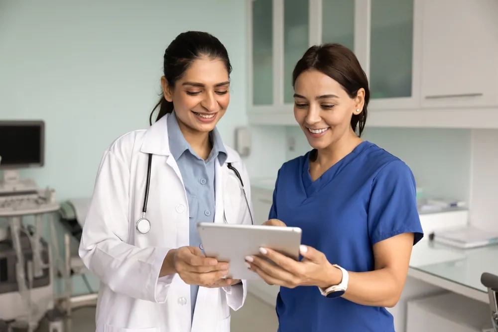 A clinical nurse leader looking over a patient's chart with an RN
