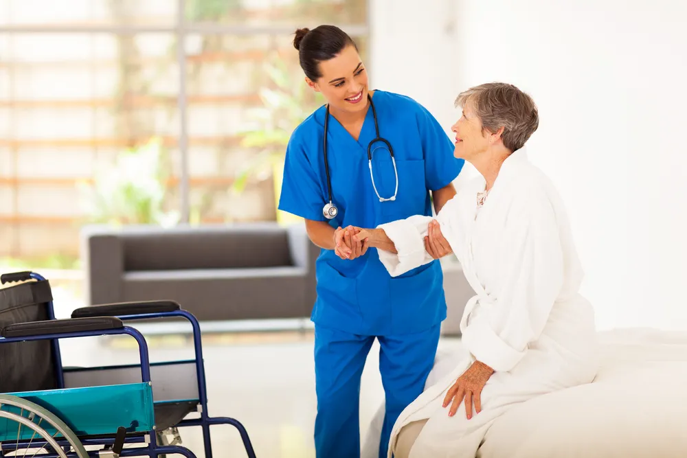 A BSN-trained nurse assisting a patient in a hospital ward