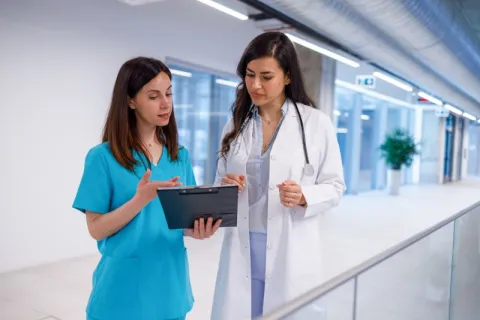 A nurse practitioner discussing a patient plan with a registered nurse