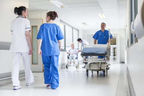 Health care professionals walking in a health care facility. 